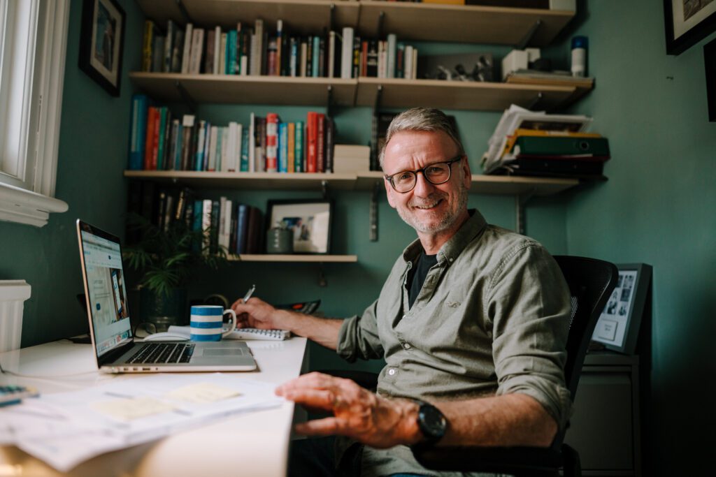 A man at his desk smiling