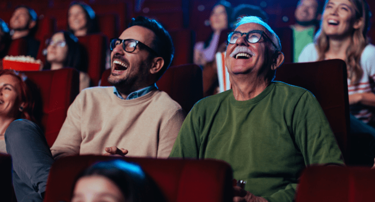 Two men laughing in a cinema