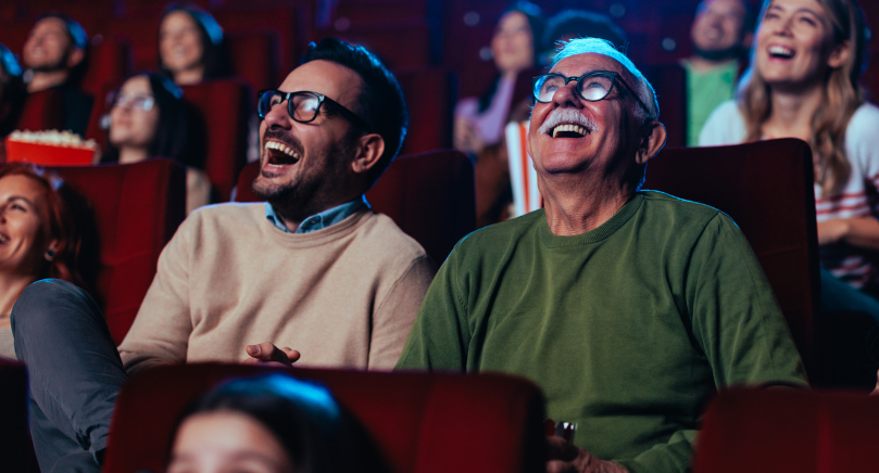 Two men laughing in a cinema